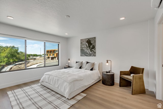 bedroom featuring baseboards, recessed lighting, and light wood-type flooring