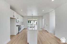 kitchen featuring white cabinetry, stainless steel appliances, decorative light fixtures, light hardwood / wood-style flooring, and sink
