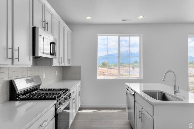 1972 S 2475 W, West Haven, UT 84401 - kitchen with appliances with stainless steel finishes, a sink, light wood finished floors, tasteful backsplash, and light countertops