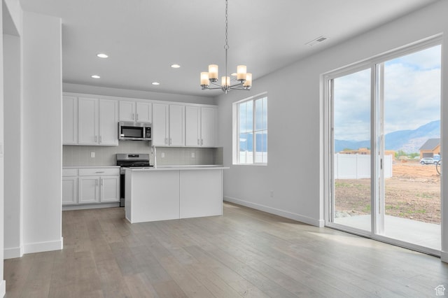 1972 S 2475 W, West Haven, UT 84401 - kitchen featuring appliances with stainless steel finishes, recessed lighting, a chandelier, white cabinetry, and backsplash
