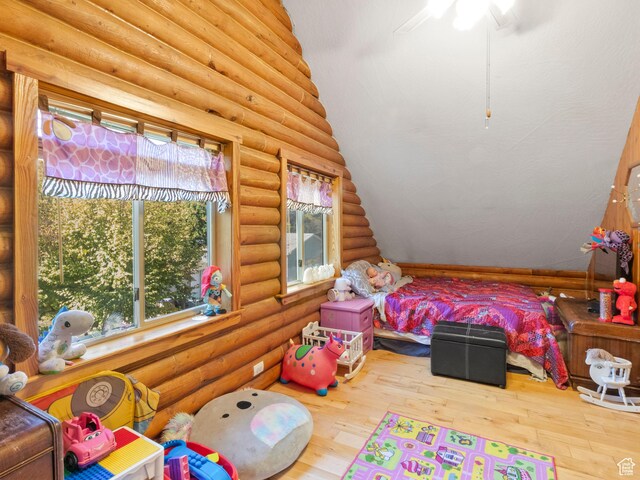 bedroom with log walls and wood finished floors