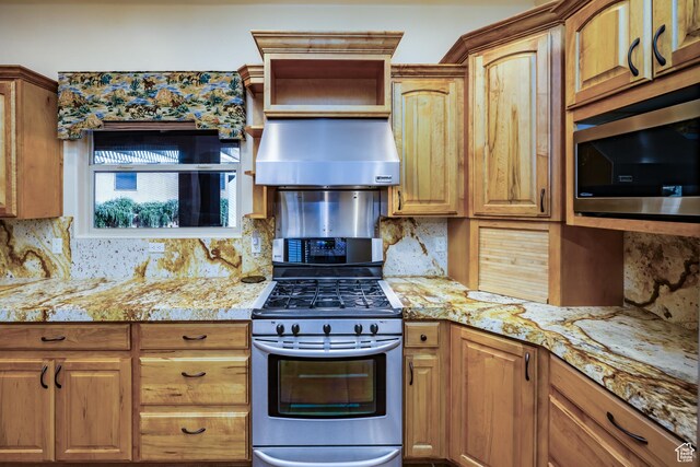 865 Seminole Way S, Washington, UT 84780 - kitchen featuring wall chimney range hood, tasteful backsplash, light stone countertops, and appliances with stainless steel finishes