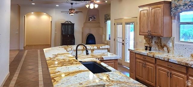 865 Seminole Way S, Washington, UT 84780 - kitchen with tasteful backsplash, light stone counters, ceiling fan, arched walkways, and a sink