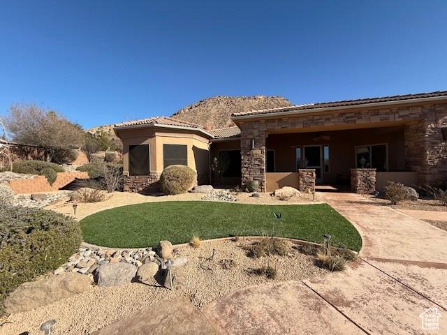 865 Seminole Way S, Washington, UT 84780 - view of front of home featuring a front yard, a tile roof, stone siding, and stucco siding