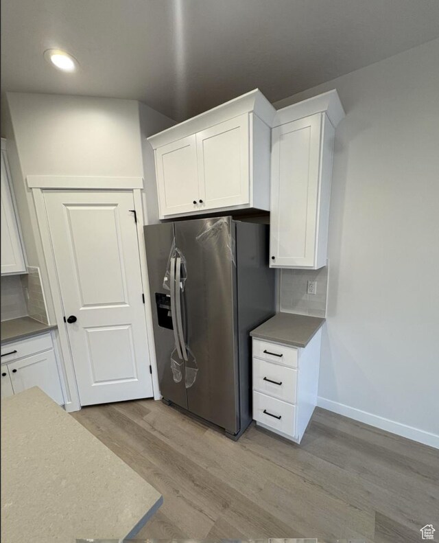 kitchen with white cabinets and stainless steel refrigerator with ice dispenser