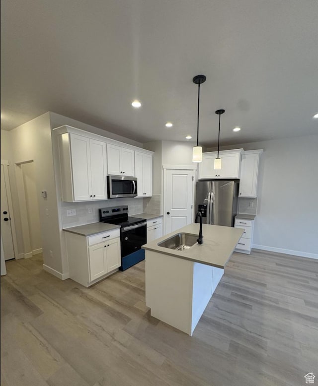 kitchen with hanging light fixtures, white cabinetry, and stainless steel appliances