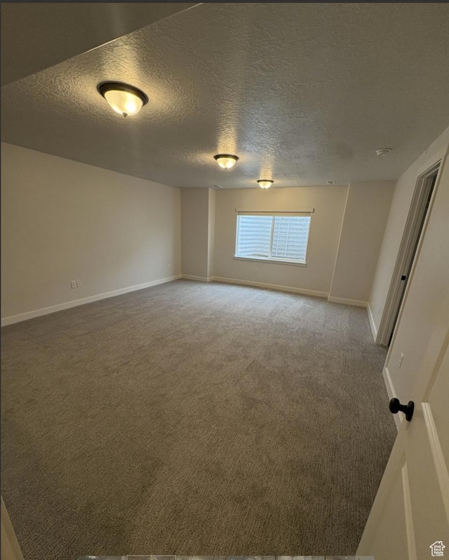 carpeted empty room featuring a textured ceiling