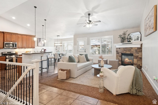 672 W 1900 S, Syracuse, UT 84075 - living area featuring ceiling fan, vaulted ceiling, light tile patterned floors, a stone fireplace, and recessed lighting