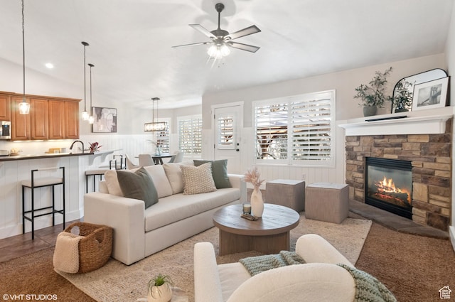 672 W 1900 S, Syracuse, UT 84075 - living area featuring vaulted ceiling, a fireplace, a wainscoted wall, and ceiling fan