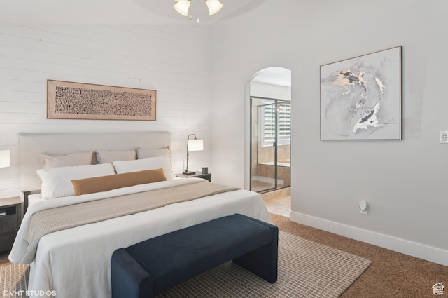 672 W 1900 S, Syracuse, UT 84075 - bedroom featuring baseboards, arched walkways, wood walls, light carpet, and connected bathroom