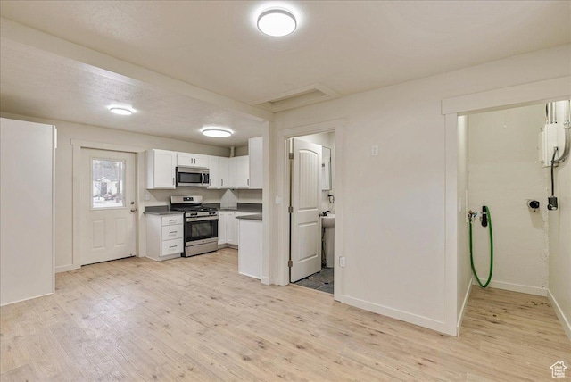 670 16th St, Ogden, UT 84404 - kitchen with appliances with stainless steel finishes, light wood-type flooring, and white cabinetry