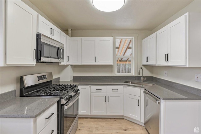 670 16th St, Ogden, UT 84404 - kitchen with sink, white cabinets, stainless steel appliances, and light hardwood / wood-style floors