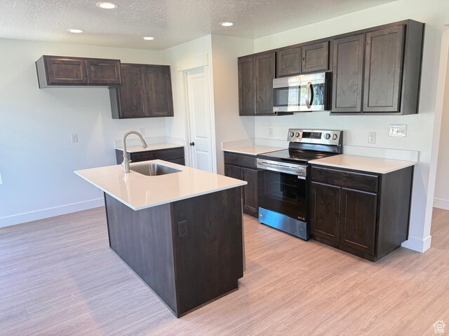 1949 S Freestone Blvd Unit 417, Santaquin, UT 84655 - kitchen with appliances with stainless steel finishes, a sink, light wood finished floors, baseboards, and a textured ceiling