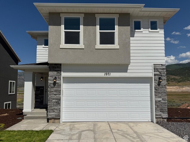 1949 S Freestone Blvd Unit 417, Santaquin, UT 84655 - view of front of property featuring stone siding, driveway, an attached garage, and a mountain view