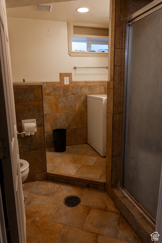 bathroom with toilet, tile walls, and a shower