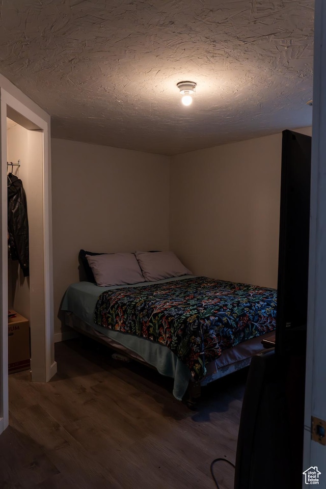 bedroom with wood-type flooring and a textured ceiling