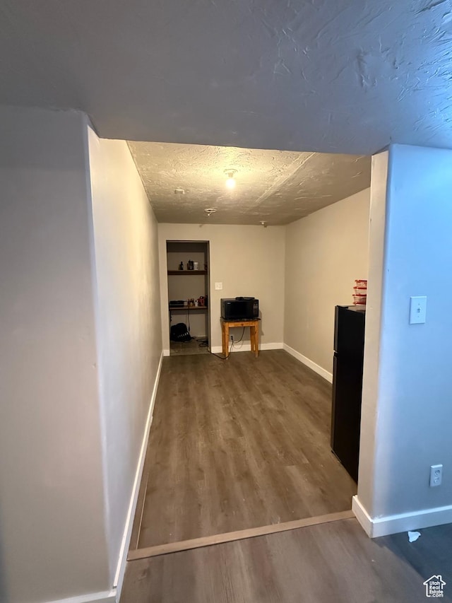 basement featuring a textured ceiling and hardwood / wood-style floors