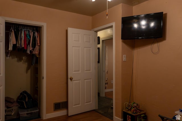 bedroom with a closet and hardwood / wood-style flooring