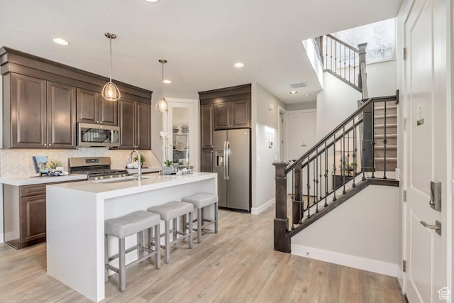 3791 S 3235 W Unit 15, West Haven, UT 84401 - kitchen with a center island with sink, hanging light fixtures, stainless steel appliances, dark brown cabinetry, and sink