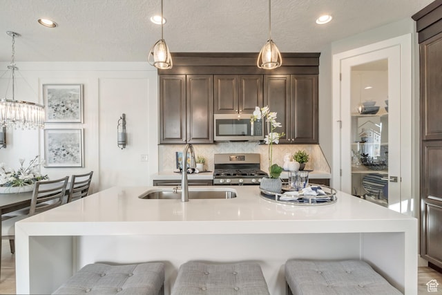3791 S 3235 W Unit 15, West Haven, UT 84401 - kitchen with appliances with stainless steel finishes, a kitchen breakfast bar, and a kitchen island with sink