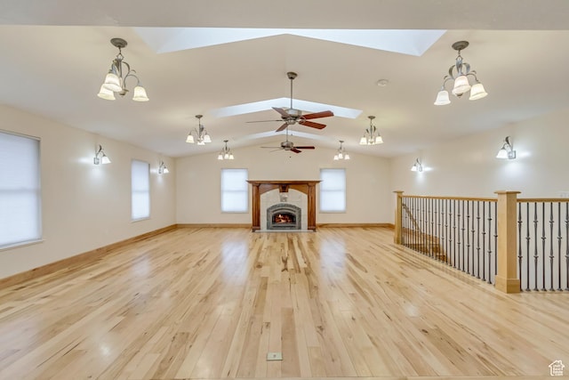 3780 W 5850 S, Roy, UT 84067 - unfurnished living room with vaulted ceiling with skylight, light hardwood / wood-style floors, and ceiling fan with notable chandelier