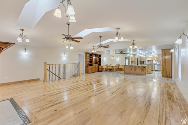 3780 W 5850 S, Roy, UT 84067 - unfurnished living room with ceiling fan with notable chandelier, vaulted ceiling with skylight, and light hardwood / wood-style flooring