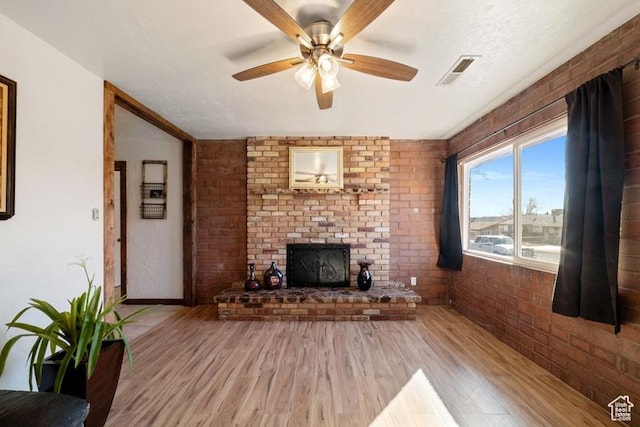 992 N 2050 E, St George, UT 84770 - unfurnished living room with a brick fireplace, hardwood / wood-style flooring, ceiling fan, and brick wall