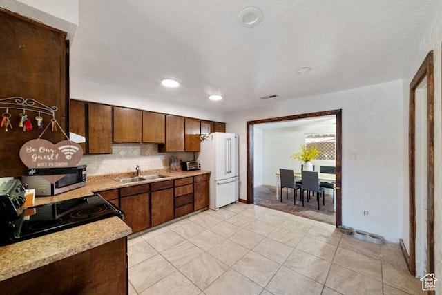 992 N 2050 E, St George, UT 84770 - kitchen featuring decorative backsplash, white refrigerator, electric range, light tile patterned floors, and sink