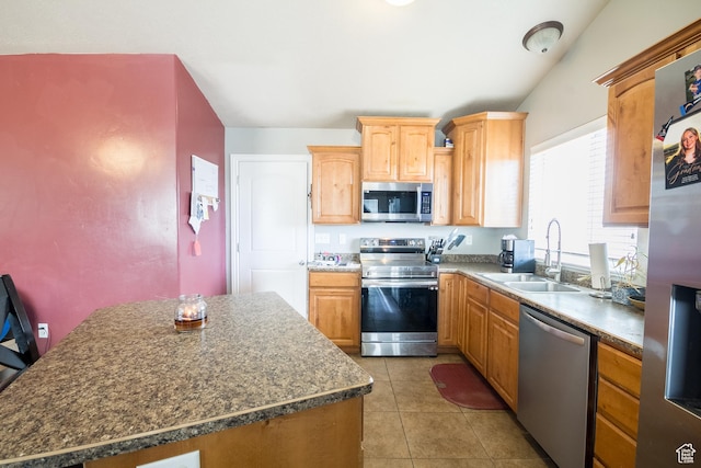kitchen with appliances with stainless steel finishes, sink, and light tile patterned floors