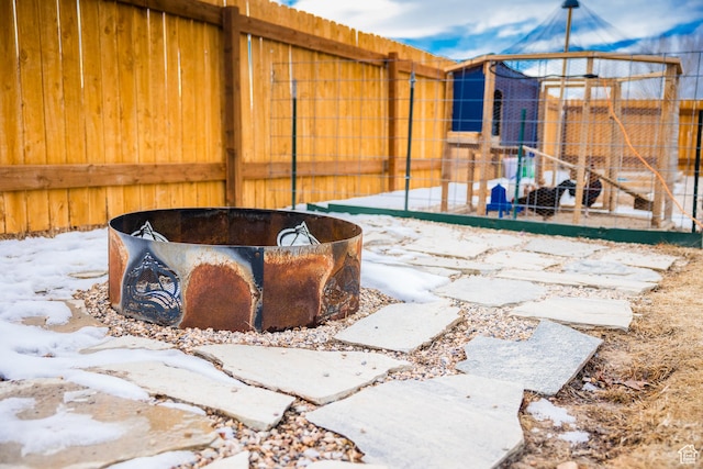snow covered patio featuring a fire pit