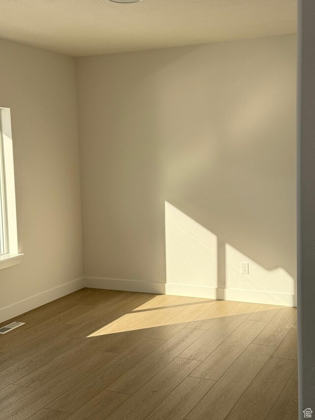 2895 E Liam Ln Unit 106, Eagle Mountain, UT 84005 - unfurnished room featuring visible vents, wood finished floors, and baseboards