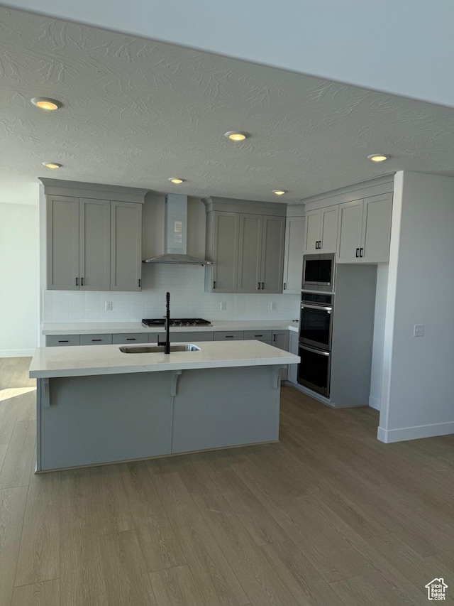 2895 E Liam Ln Unit 106, Eagle Mountain, UT 84005 - kitchen with wall chimney exhaust hood, light countertops, gray cabinetry, and a sink