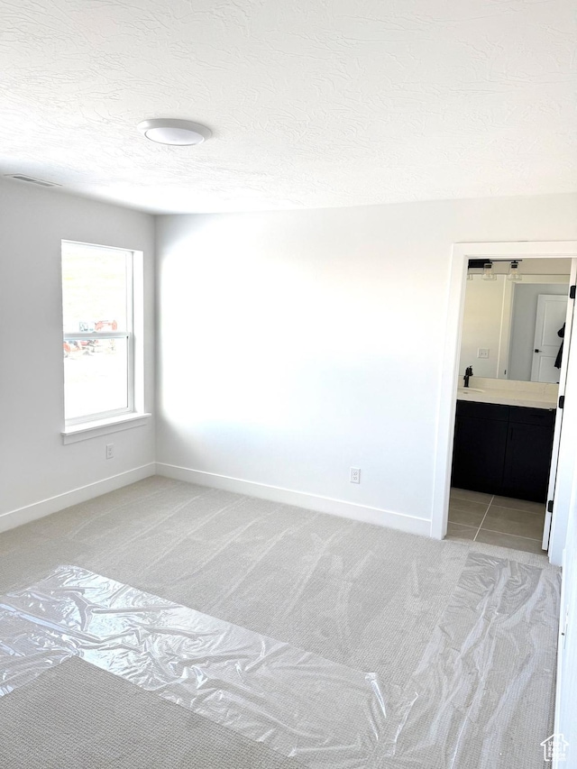 2895 E Liam Ln Unit 106, Eagle Mountain, UT 84005 - spare room featuring a textured ceiling, light carpet, and baseboards