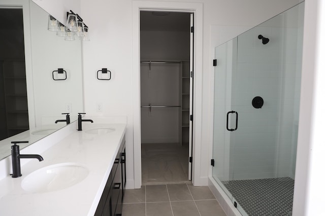 2895 E Liam Ln Unit 106, Eagle Mountain, UT 84005 - bathroom featuring a stall shower, a walk in closet, double vanity, and tile patterned floors