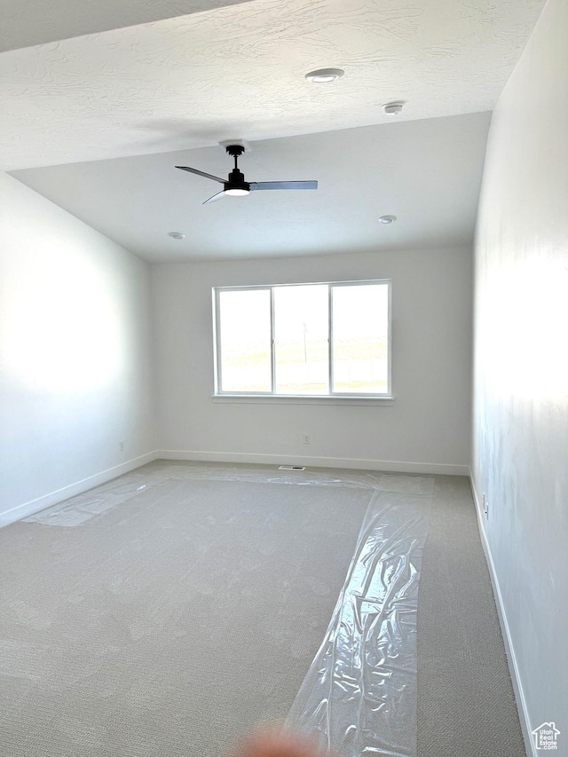 2895 E Liam Ln Unit 106, Eagle Mountain, UT 84005 - spare room with light colored carpet, a textured ceiling, a ceiling fan, and baseboards