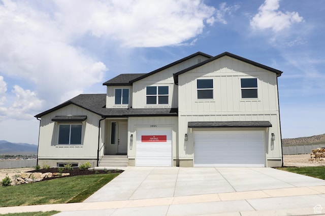 2895 E Liam Ln Unit 106, Eagle Mountain, UT 84005 - view of front of house featuring a garage, a shingled roof, driveway, board and batten siding, and a mountain view