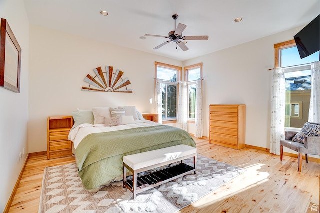 bedroom with baseboards, recessed lighting, multiple windows, and light wood-type flooring