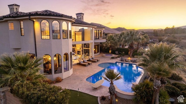 2024 W 450th Cir S, St George, UT 84770 - back of house with a balcony, a chimney, an outdoor pool, a patio area, and stucco siding