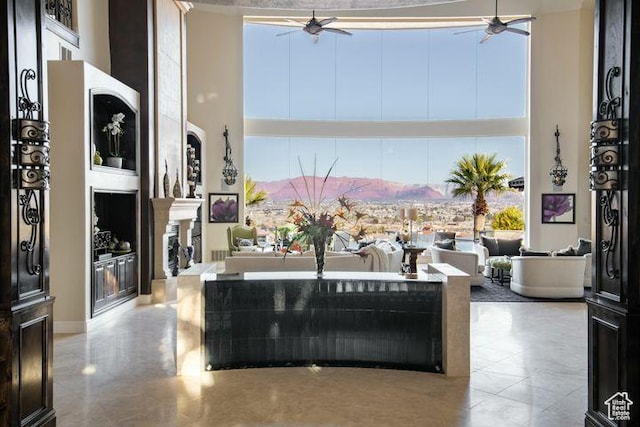 2024 W 450th Cir S, St George, UT 84770 - living area featuring a towering ceiling, a warm lit fireplace, and a ceiling fan