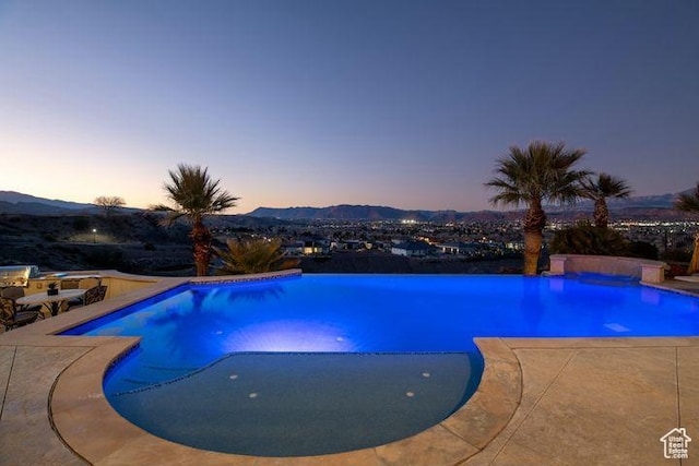2024 W 450th Cir S, St George, UT 84770 - pool at dusk featuring an outdoor pool, a mountain view, and a patio area