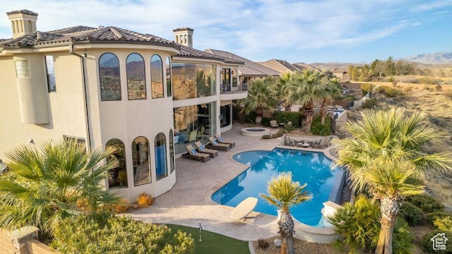2024 W 450th Cir S, St George, UT 84770 - back of property featuring a fire pit, stucco siding, a balcony, and a patio area