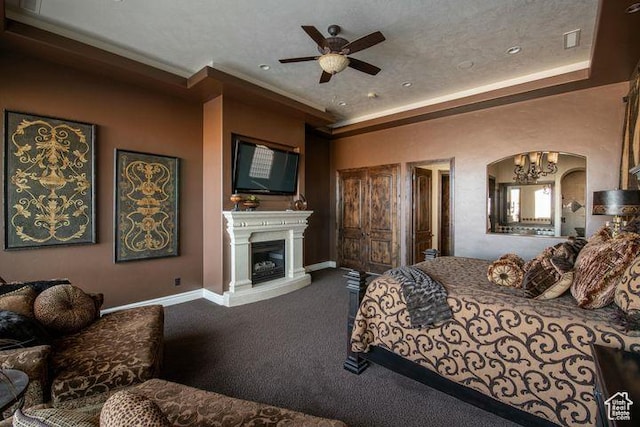 2024 W 450th Cir S, St George, UT 84770 - carpeted bedroom with a fireplace with raised hearth, ornamental molding, baseboards, arched walkways, and a tray ceiling