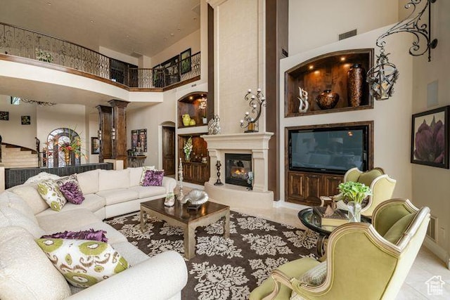 2024 W 450th Cir S, St George, UT 84770 - living area featuring arched walkways, visible vents, decorative columns, a large fireplace, and a high ceiling