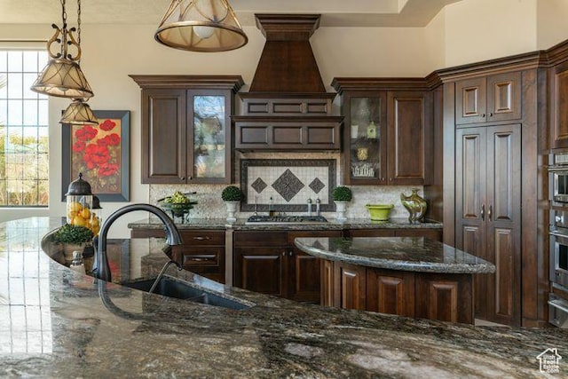 2024 W 450th Cir S, St George, UT 84770 - kitchen with a sink, decorative light fixtures, dark brown cabinetry, and glass insert cabinets