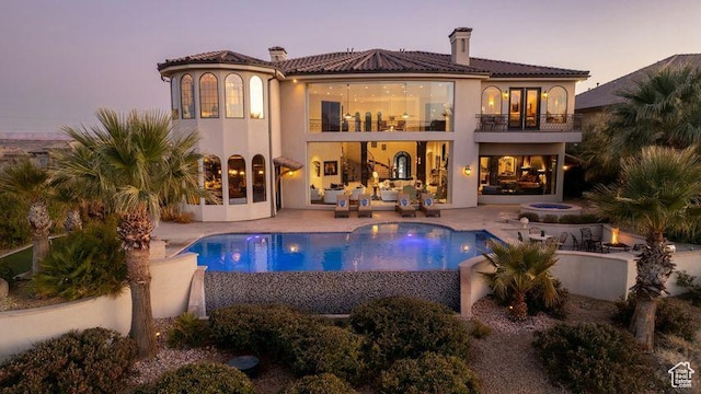 2024 W 450th Cir S, St George, UT 84770 - rear view of property featuring a tiled roof, a patio, a balcony, a fenced in pool, and a chimney