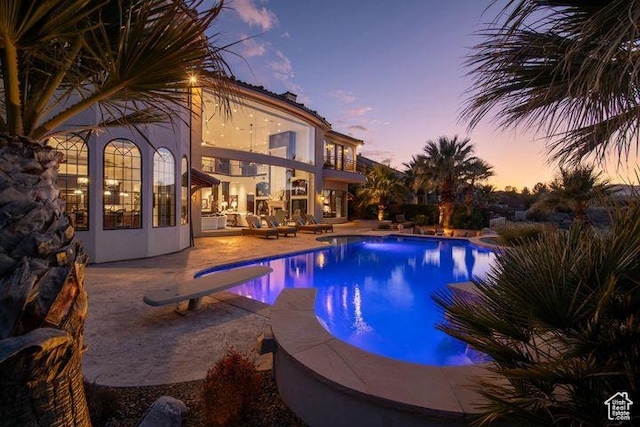 2024 W 450th Cir S, St George, UT 84770 - pool at dusk with an outdoor pool, a patio, and a diving board