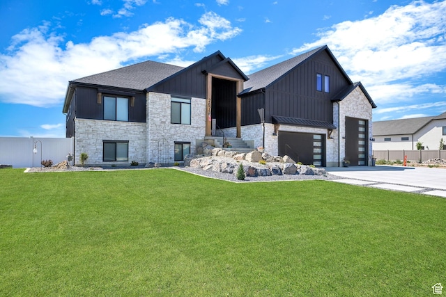 view of front of home featuring stone siding, a front yard, board and batten siding, and concrete driveway