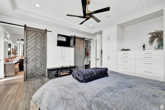 2673 S 4950 W, Taylor, UT 84401 - bedroom featuring recessed lighting, a raised ceiling, a barn door, light wood-style floors, and ceiling fan