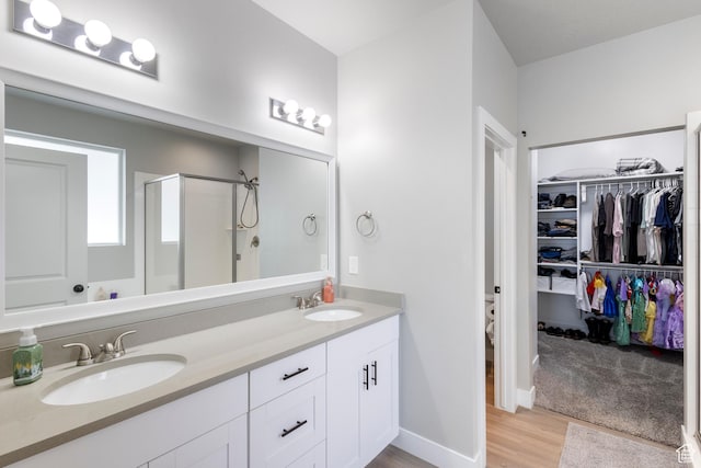 4142 N Fairfield Dr, Eagle Mountain, UT 84005 - bathroom with double vanity, a stall shower, a spacious closet, and a sink