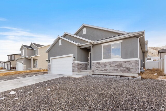 4142 N Fairfield Dr, Eagle Mountain, UT 84005 - view of front of home with a garage, stone siding, driveway, a residential view, and stucco siding